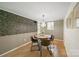Cozy dining room featuring a modern chandelier, stylish wallpaper, and seating for four at 3737 Winding Creek Ln, Charlotte, NC 28226