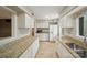 Well-lit kitchen featuring granite counters, white cabinets, and stainless steel appliances at 3737 Winding Creek Ln, Charlotte, NC 28226