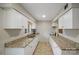 Functional kitchen with granite countertops, white cabinetry, and neutral-colored tile flooring at 3737 Winding Creek Ln, Charlotte, NC 28226