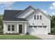 Charming new construction home featuring white vertical siding, a dark roof, a two-car garage, and professional landscaping at 4146 Eastover Glen Rd # 0322, Charlotte, NC 28269