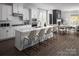 A kitchen features a large island with seating, modern appliances, and an open-concept design leading into the dining and living areas at 4146 Eastover Glen Rd # 0322, Charlotte, NC 28269
