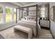 A primary bedroom features a four-poster bed, neutral décor, and large windows allowing for plenty of natural light at 4146 Eastover Glen Rd # 0322, Charlotte, NC 28269