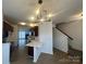 Open concept kitchen with white countertops, dark cabinets, and modern light fixture near stairs at 4208 Coulter Xing, Charlotte, NC 28213