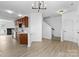 Open-concept living area featuring modern lighting, hardwood floors, kitchen access, and a staircase at 4208 Coulter Xing, Charlotte, NC 28213