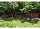 Landscaped backyard with brick perimeter and mature trees at 4232 Randolph Rd, Charlotte, NC 28211