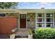 Front exterior with stone accents, a brick facade, landscaped bushes, and a tiled front step at 4232 Randolph Rd, Charlotte, NC 28211