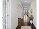 Elegant hallway featuring dark hardwood flooring, white arched doorways, and a bench adorned with flowers at 4310 Coachwhip Ave, Lancaster, SC 29720
