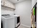 Well-equipped laundry room features a modern washer and dryer set, efficient storage shelves, and functional accessories at 4310 Coachwhip Ave, Lancaster, SC 29720