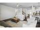 Spacious living room showcasing dark hardwood floors, neutral furniture, and seamless flow to the kitchen at 4310 Coachwhip Ave, Lancaster, SC 29720