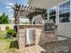 Outdoor kitchen featuring stainless steel grill, granite counters, brick surround, and storage access at 4310 Coachwhip Ave, Lancaster, SC 29720