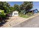 White detached garage with ample parking space and a glimpse of the blue house at 455 Wood Ave, Kannapolis, NC 28083