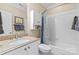 Well-lit bathroom featuring a vanity with granite countertop and a tub with shower at 4740 Myers Ln, Harrisburg, NC 28075