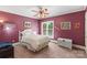 Bedroom with a white bed, and a wicker chest in a space with a plum color scheme at 4740 Myers Ln, Harrisburg, NC 28075