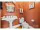 Powder room featuring a pedestal sink, ornate mirror, and decorative accents at 4740 Myers Ln, Harrisburg, NC 28075