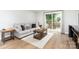 Cozy living room with hardwood floors, neutral decor, and sliding door to outdoor deck at 5843 Timber Falls Nw Pl, Concord, NC 28027