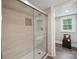 Modern bathroom featuring a glass-enclosed shower with tan tiling and decor shelf at 81 21St Nw Ave, Hickory, NC 28601