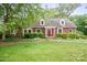 Charming brick home with a well-manicured lawn, complemented by a vibrant red door and inviting greenery at 81 21St Nw Ave, Hickory, NC 28601