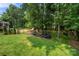 Large, green backyard with play equipment, mature trees, and a wood fence surrounding the property at 8500 Headford Rd, Charlotte, NC 28277