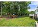 Spacious backyard with a wooden playset, trampoline, and mature trees providing plenty of shade at 8500 Headford Rd, Charlotte, NC 28277