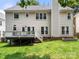 Rear exterior view of the home featuring a deck, green grass, and mature trees on a sunny day at 8500 Headford Rd, Charlotte, NC 28277