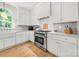 Kitchen featuring stainless steel range, white cabinets, marble backsplash, and an arched window at 8500 Headford Rd, Charlotte, NC 28277