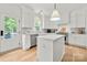 Kitchen with stainless steel appliances, marble countertops, white cabinets and island, and a view to the backyard at 8500 Headford Rd, Charlotte, NC 28277