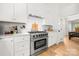 Kitchen featuring stainless steel range, white cabinets, marble backsplash, and hardwood flooring at 8500 Headford Rd, Charlotte, NC 28277