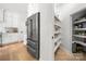 Kitchen with a stainless steel refrigerator, ample shelving in the pantry, and wood floors at 8500 Headford Rd, Charlotte, NC 28277