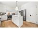 Elegant white kitchen with an island, stainless steel appliances, marble backsplash, and hardwood flooring at 8500 Headford Rd, Charlotte, NC 28277