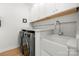 Well-lit laundry room featuring modern appliances and a stylish sink with white cabinetry at 8500 Headford Rd, Charlotte, NC 28277