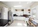 Bright kitchen with white cabinets, stainless steel refrigerator, and tiled flooring at 101 Sunset Dr, Stanley, NC 28164