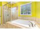 Relaxing bathroom with a glass shower and a luxurious soaking tub, illuminated by natural light at 10105 Community House Rd, Charlotte, NC 28277