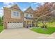 Beautiful two-story home featuring brick and siding exterior, a well-manicured lawn, and a two car garage at 10105 Community House Rd, Charlotte, NC 28277