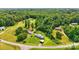 Aerial view of a property with lush, mature trees and a home with a deck and shed on green grass at 1016 S D Ave, Maiden, NC 28650