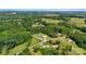 Aerial view of property including surrounding trees, open fields, and neighboring properties at 1016 S D Ave, Maiden, NC 28650