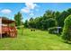 Spacious, green backyard featuring mature trees and a fire pit, perfect for outdoor activities at 1016 S D Ave, Maiden, NC 28650