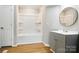 Nicely updated bathroom features a shower/tub combo and vanity with a round mirror at 1016 S D Ave, Maiden, NC 28650