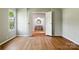 A cozy bedroom with light gray walls and wood-look flooring connects to a bathroom with a round mirror at 1016 S D Ave, Maiden, NC 28650