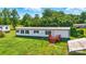 Exterior of a white home with a brown metal roof and a brown wooden deck surrounded by green grass and trees at 1016 S D Ave, Maiden, NC 28650