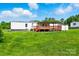 Exterior of a white home with a deck and storage shed surrounded by green grass and mature trees at 1016 S D Ave, Maiden, NC 28650