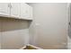 Utility room featuring white cabinets for storage, light grey walls, and light hardwood flooring at 1016 S D Ave, Maiden, NC 28650