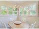 Cozy dining area with wood table, four chairs, and modern chandelier near large windows at 1062 Willow Ridge Ln, Fort Mill, SC 29707