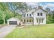 Beautiful two-story farmhouse with white siding, black trim, inviting front porch, and a detached garage at 1062 Willow Ridge Ln, Fort Mill, SC 29707