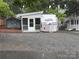 Exterior view of the Pioneer modular home on lot 204, with white siding, screened porch, and gravel driveway at 107 Pine St, New London, NC 28127