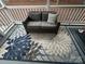 A cozy, comfortable love seat sits on the patio, with a floral rug underneath and a decorative pillow at 107 Pine St, New London, NC 28127