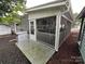 Covered screened porch with concrete patio on lot 204 with white siding and gray trim at 107 Pine St, New London, NC 28127