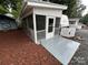 Covered screened porch with concrete patio on lot 204 with white siding and gray trim at 107 Pine St, New London, NC 28127