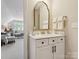 Bathroom vanity with marble countertop, undermount sink, stylish mirror and view into the living room at 1226 Restoration Dr, Waxhaw, NC 28173