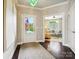 Bright foyer featuring hardwood floors, a decorative chandelier, and a glimpse into the adjacent living room at 1226 Restoration Dr, Waxhaw, NC 28173