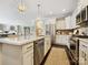 Open-concept kitchen with island seating, granite counters, stainless steel appliances, and hardwood floors at 1226 Restoration Dr, Waxhaw, NC 28173